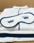 White sleep mask on top of a white shirt with navy trim