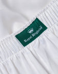 Close-up of a white garment with an elasticized waistband and a green fabric label reading 'Royal Highnies' with a white crown logo.