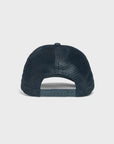 The back view of a dark navy blue trucker hat with a textured mesh pattern and adjustable snapback closure, shown on a light gray background.