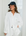 Woman wearing a white shirt and navy cap indoors with light background