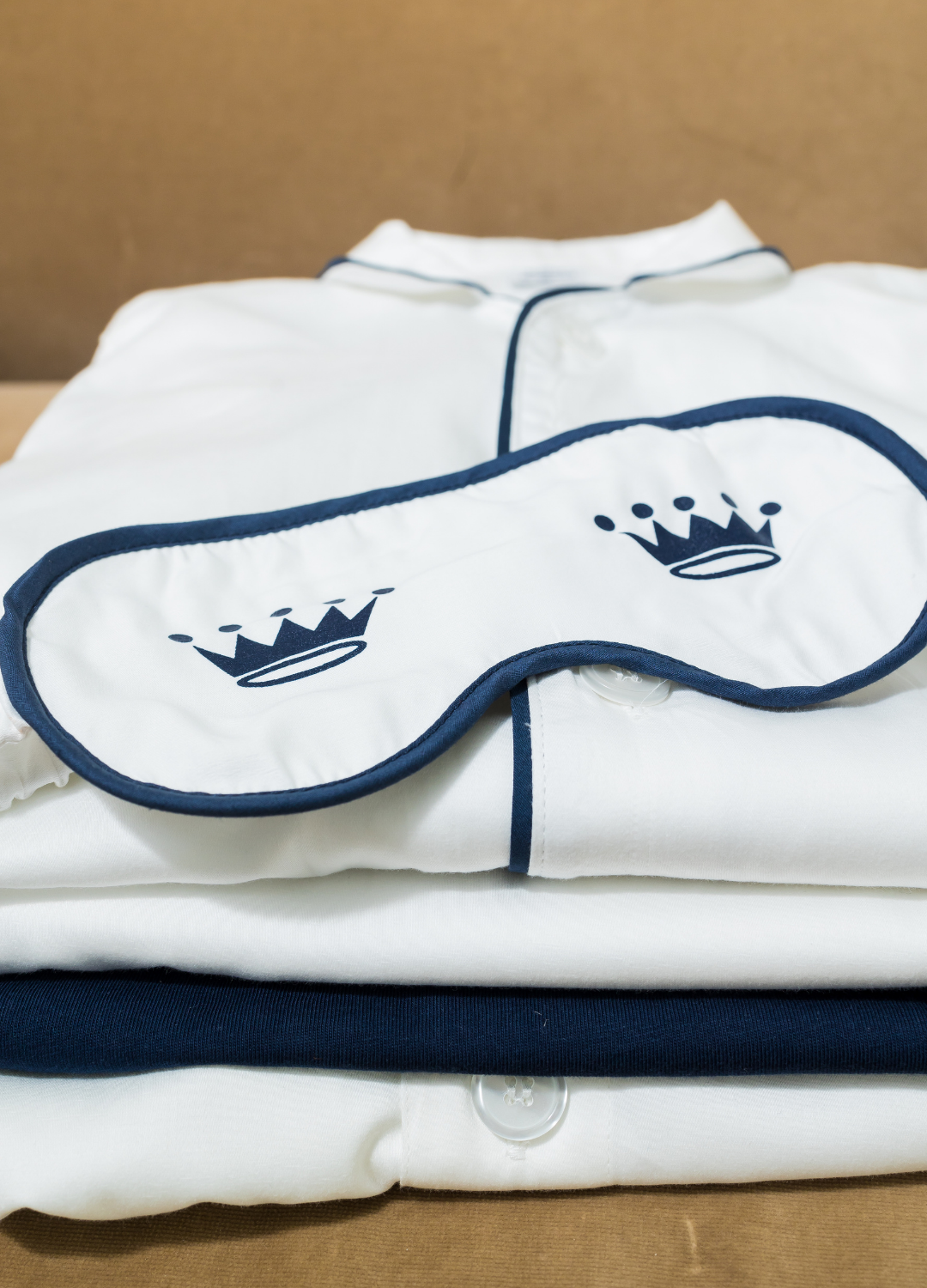 White sleep mask on top of a white shirt with navy trim