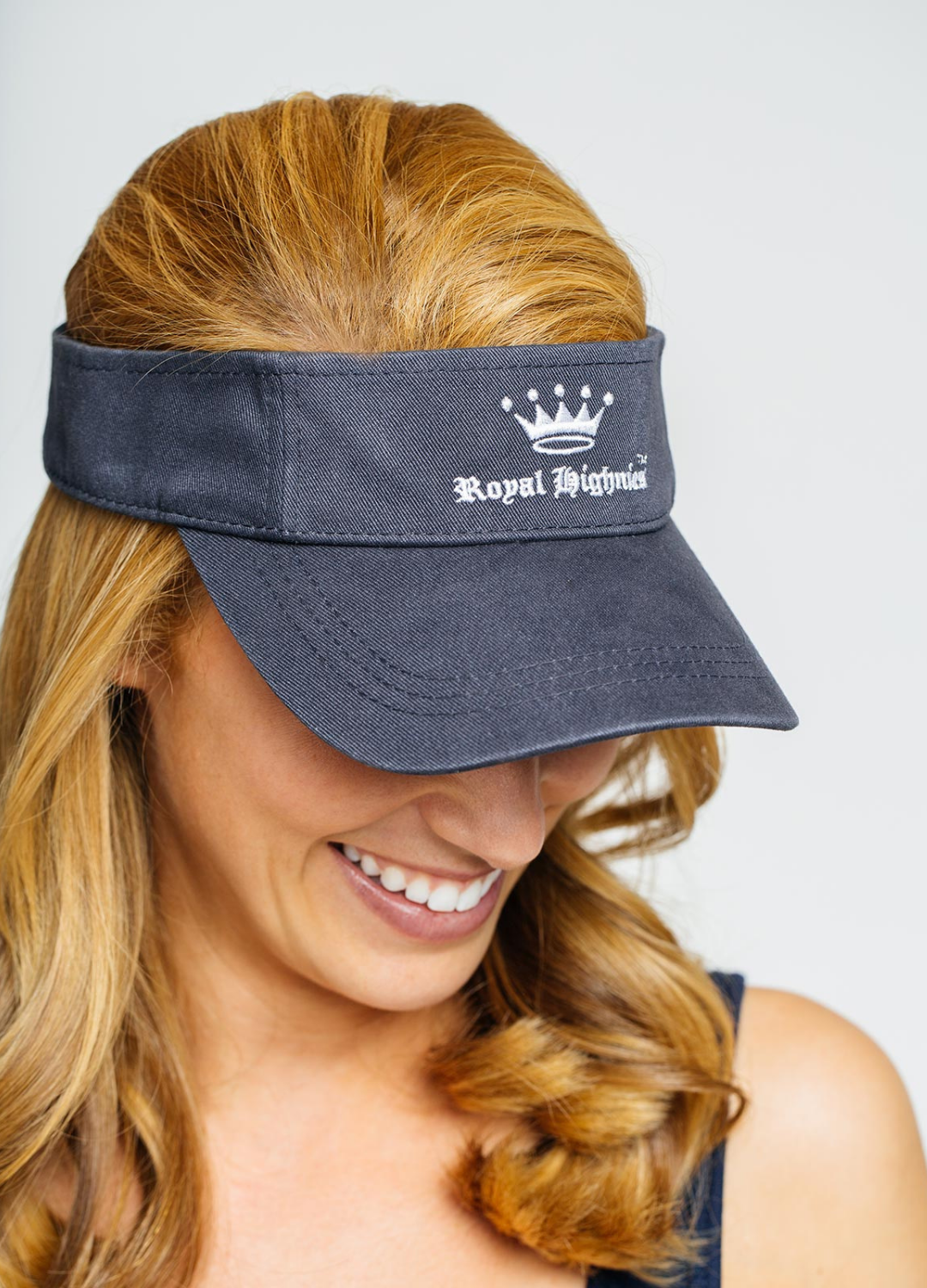 A woman wearing a navy blue visor with the 'Royal Highnies' logo on the front.