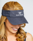 A woman wearing a navy blue visor with the 'Royal Highnies' logo on the front.