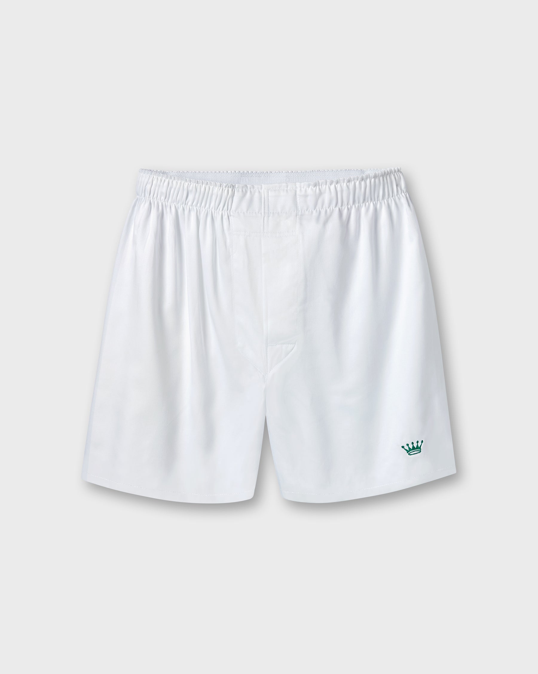 White athletic shorts with an elastic waistband and a small green crown logo on the lower left leg, shown against a light gray background.