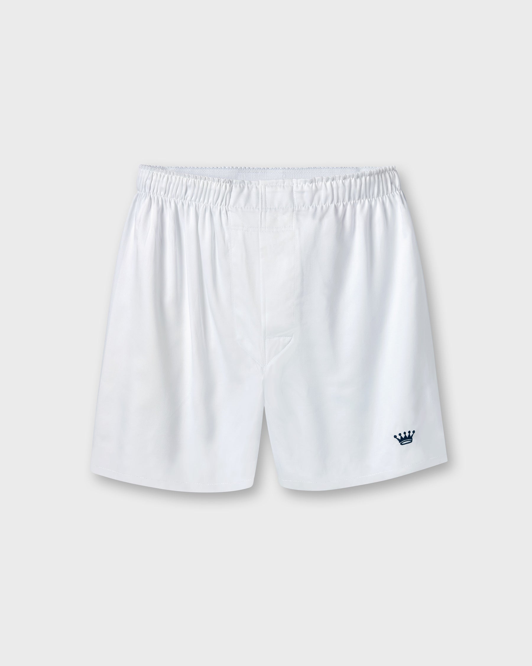 White boxers with an elastic waistband and a small navy blue crown logo on the lower left leg, shown against a light gray background.