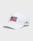 A white baseball cap featuring an embroidered American flag patch on the front and the Royal Highnies logo embroidered in navy on the side.