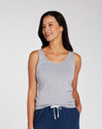 Woman wearing a light gray tank top and navy blue drawstring shorts, photographed against a clean light gray studio background.