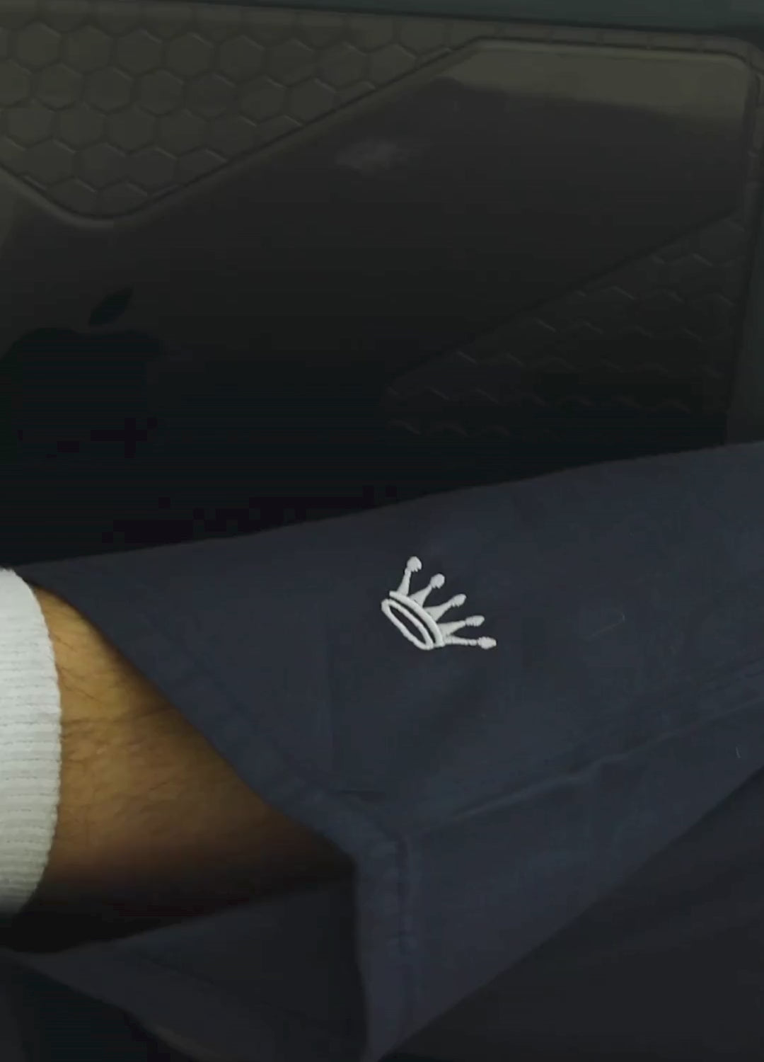 Short video clip showing a man wearing navy blue pants working on a laptop