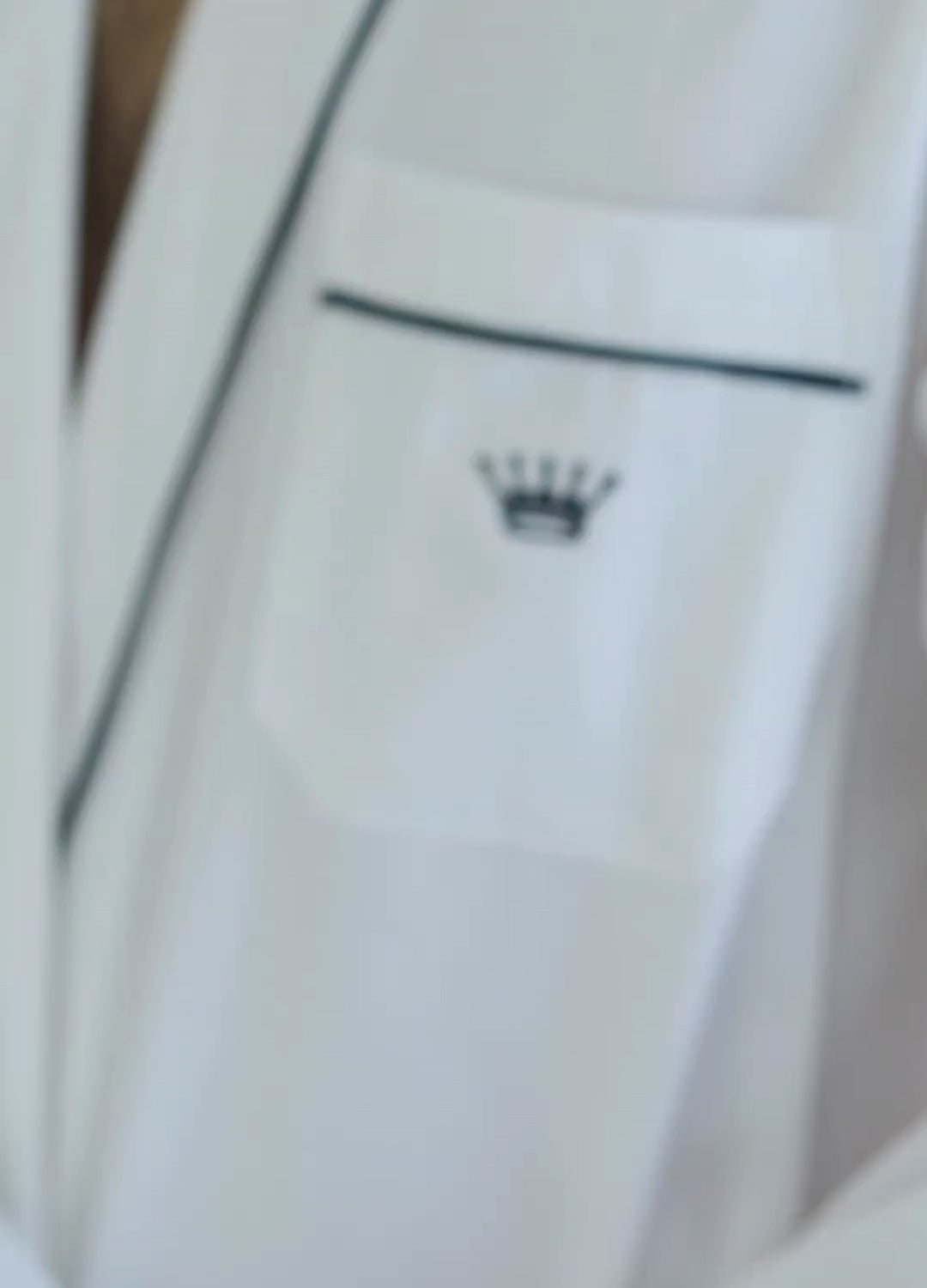 Short video clip of a person in a white robe adjusting pillows on a bed in a minimalistic room.