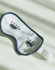 Short video clips showing a white sleep mask with two navy crown logos