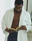 Short video clip showing a man wearing navy blue boxers and a white top while reading.