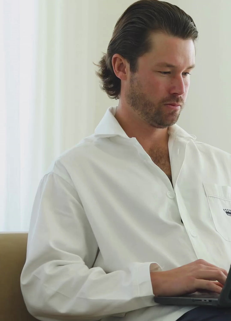 Short video clip showing a man wearing a white button-up shirt working on a laptop