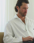 Short video clip showing a man wearing a white button-up shirt working on a laptop