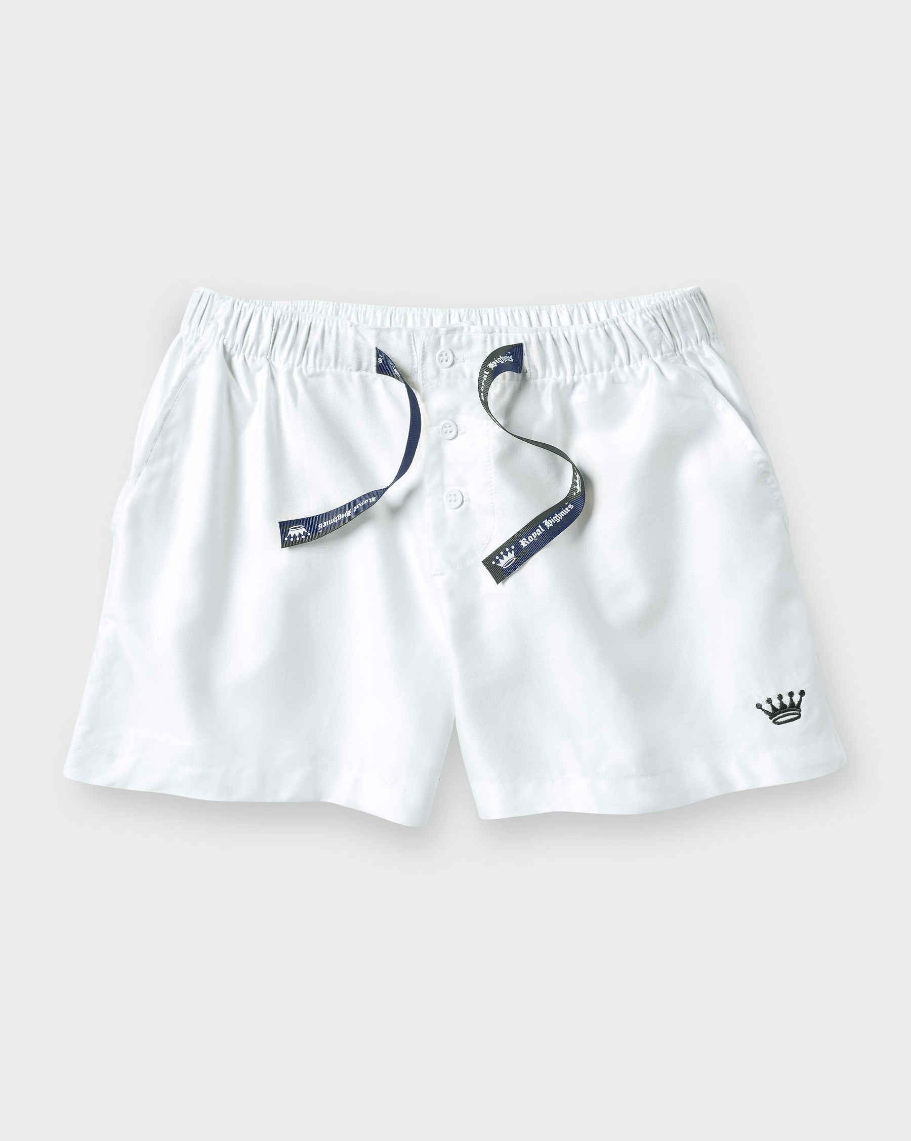White drawstring shorts with a navy blue embroidered crown logo on the lower left and a matching navy blue drawstring with a brand tag.